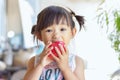 Asian child girl eating and biting an red apple. Enjoy